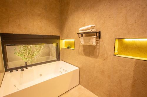 a bathroom with a bath tub and a window at شاليهات العزيزية الفندقية in Buraydah