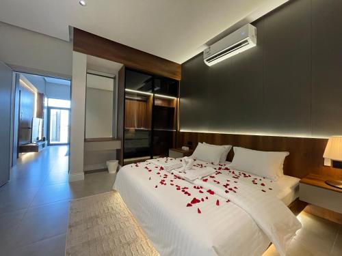 a bedroom with a bed with red rose petals on it at شاليهات العزيزية الفندقية in Buraydah