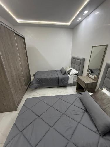 a bedroom with a bed and a couch and a table at Appart Résidence Sabrin in Fnidek