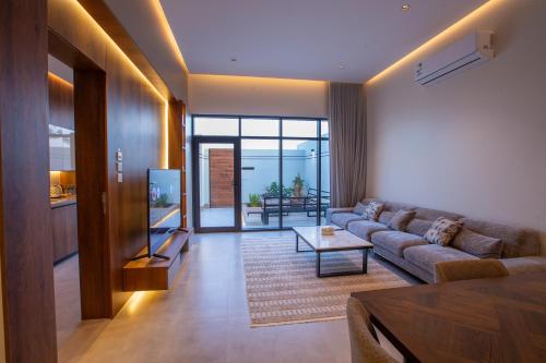 a living room with a couch and a table at شاليهات العزيزية الفندقية in Buraydah