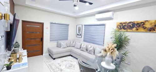 a living room with a couch and a glass table at Modern Island Escape -Pool-Gym & Patio in Ocho Rios
