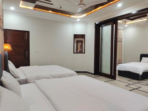 a bedroom with two beds and a window at Vision 2 Islamabad in Islamabad