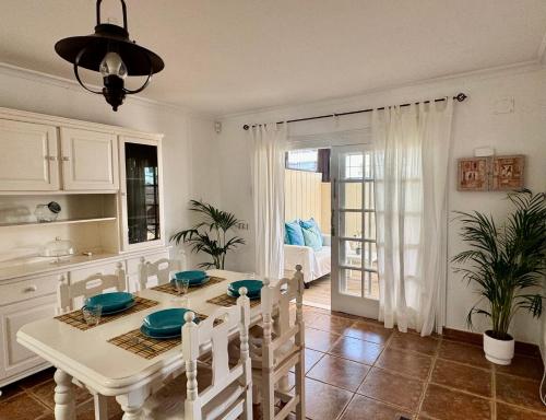 a kitchen and dining room with a white table and chairs at Villa Morriña by Vulcano Homes in Playa Honda