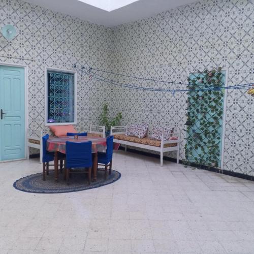 a room with a table and chairs and a bed at Bouchama's Arabesque house in Mahdia