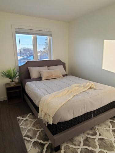 レジャイナにあるEntire Upper Level Suite - East Reginaの窓付きのベッドルームの大型ベッド1台