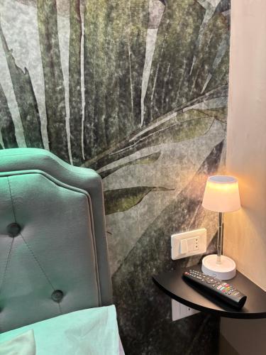 a bedroom with a green chair and a table with a lamp at Dimora Camilla apartment intero appartamento in Foggia