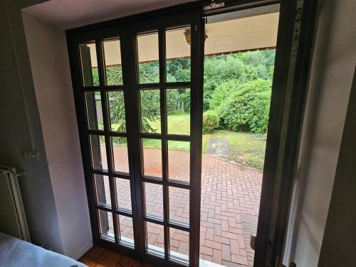 an open door with a view of a brick walkway at Monteuerunterkunft FineWood Pension 