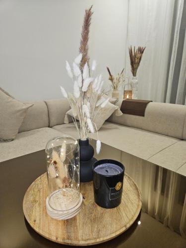 a table with a glass jar and a vase with plants at Appartement de luxe en Résidence de luxe avec 6 piscines in Saidia 