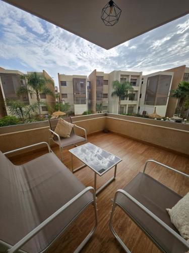 a balcony with chairs and a table on a building at Appartement de luxe en Résidence de luxe avec 6 piscines in Saidia 