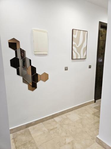 a white wall with a piece of art on it at Appartement de luxe en Résidence de luxe avec 6 piscines in Saidia 