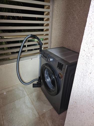a washing machine with a hose hooked up to a wall at Appartement de luxe en Résidence de luxe avec 6 piscines in Saidia 