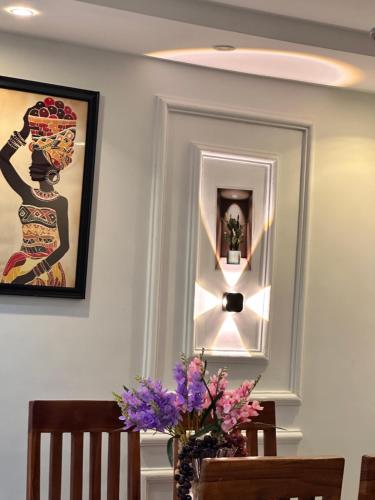 a room with a table with a vase of purple flowers at Arek Condos Accra in Sotuom