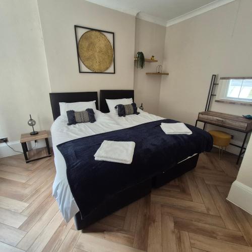 a bedroom with a large bed with two towels on it at Central Brighton, 2 bedrooms, sleeps 5 in Brighton & Hove