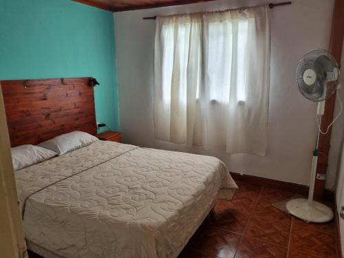 a bedroom with a bed and a fan and a window at complejo lo de Elvira in Miramar