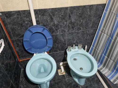a blue toilet and a sink in a bathroom at complejo lo de Elvira in Miramar