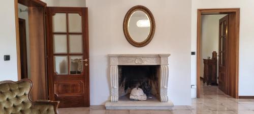 a living room with a fireplace and a mirror at la dimora di Fonte Vecchia in San Pio delle Camere