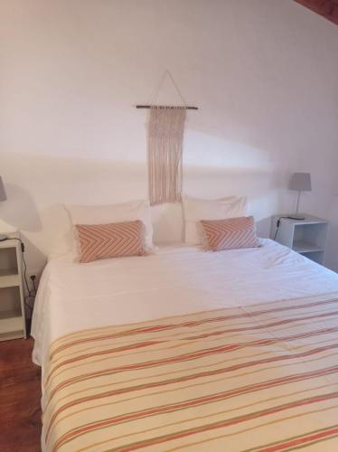 a bedroom with a large white bed with two pillows at Casa da Orada in Avis