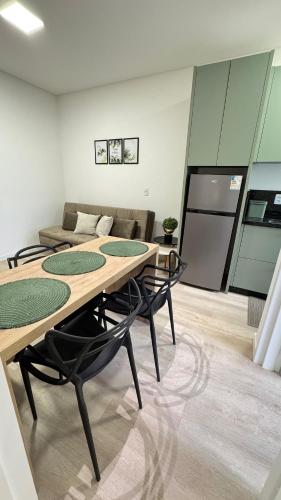 a room with a table and chairs and a couch at Apartamento 1 quarto in Brusque
