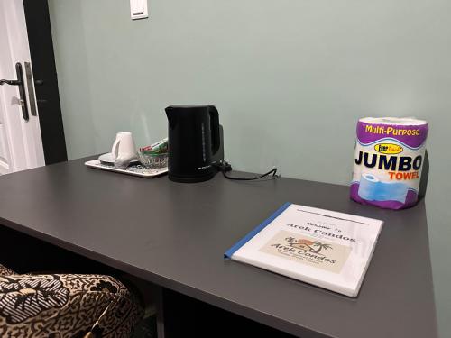 a table with a book and a bag of rumbo on it at Arek Condos Accra in Sotuom