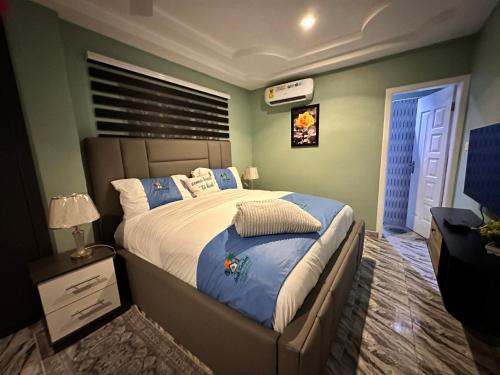 a bedroom with a large bed with blue and green walls at Arek Condos Accra in Sotuom