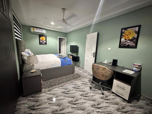 a bedroom with a bed and a desk and a desk at Arek Condos Accra in Sotuom
