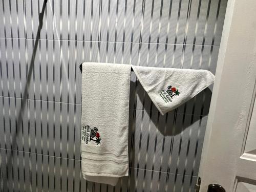 two towels are hanging on a metal wall at Arek Condos Accra in Sotuom