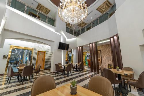 a restaurant with tables and chairs and a chandelier at السهم الذهبي للشقق المخدومة in Taif