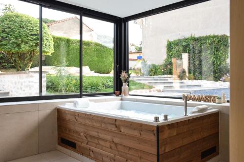 a bath tub in a room with a large window at Ciné Mirabelle 