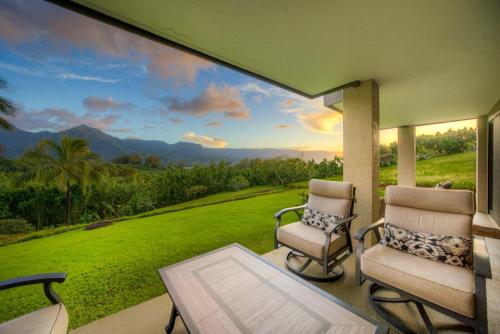 two chairs and a table on a porch with a view at Ocean and Mountain Views Hanalei Bay Resort in Princeville