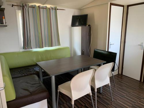 Zimmer mit einem Tisch, Stühlen und einem Sofa in der Unterkunft Casa prefabricada in El Casar de Escalona