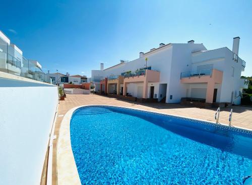ein Swimmingpool vor einem Haus in der Unterkunft Porto de Abrigo in Burgau