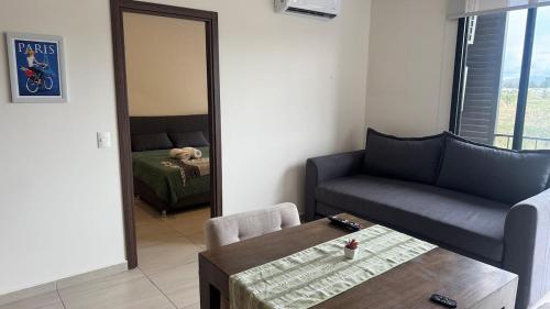 a living room with a couch and a table and a mirror at Departamento 2 Recamaras en Torre Anuva con Alberca y Gym in Guadalajara