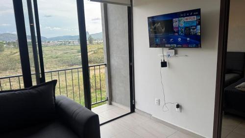 a living room with a sliding glass door with a television at Departamento 2 Recamaras en Torre Anuva con Alberca y Gym in Guadalajara