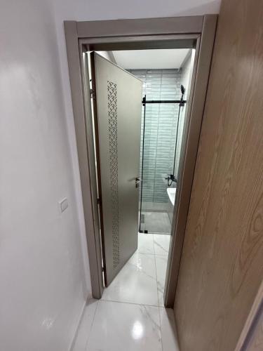 a bathroom with a glass door leading to a shower at Appart Résidence Sabrin in Fnidek