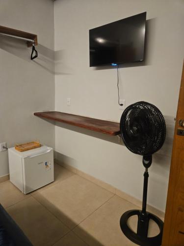 a room with a fan and a tv on a wall at Pousada Viva Paraíso in Alto Paraíso de Goiás