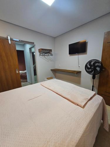 a bedroom with a bed and a flat screen tv at Pousada Viva Paraíso in Alto Paraíso de Goiás