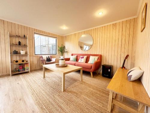 a living room with a red couch and a table at Casa Manzano ideal para Familias in Puerto Varas