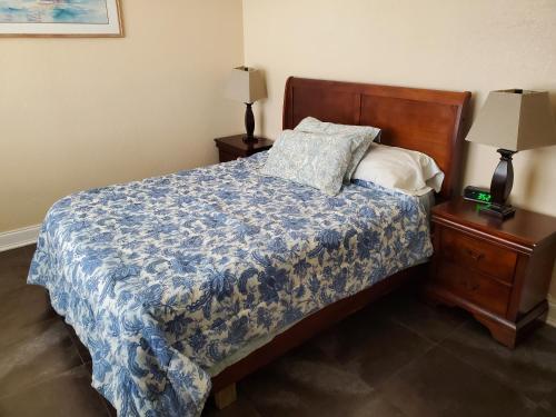 a bedroom with a bed with a blue comforter and two lamps at One Bedroom Downtown in Jacksonville