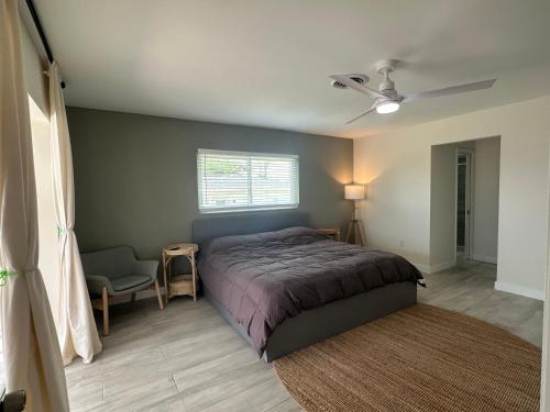 a bedroom with a bed and a chair and a window at Beautiful 2-bedroom, 2-bathroom In Rotonda West in Rotonda West