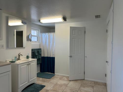 a bathroom with a sink and a white door at Charming 3-bedroom House In Delightful Englewood in Englewood