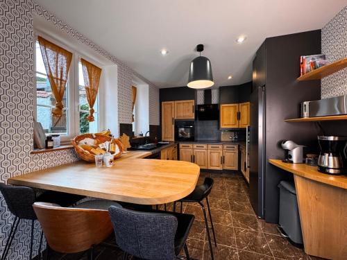 a kitchen with a wooden table and some chairs at Ciné Mirabelle 