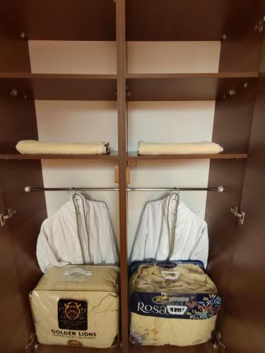 a walk in closet with two suitcases and towels at Blue Pearl Surf House Morocco in Oulad Akkou