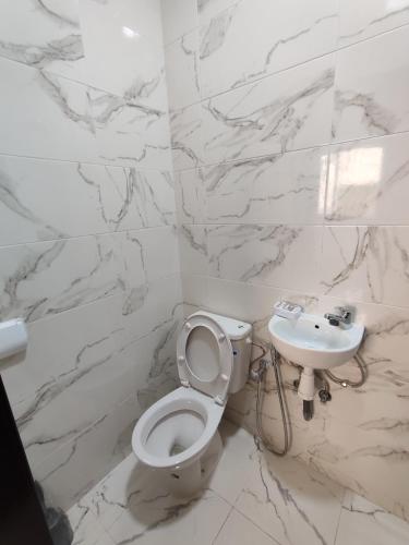 a white bathroom with a toilet and a sink at Blue Pearl Surf House Morocco in Oulad Akkou