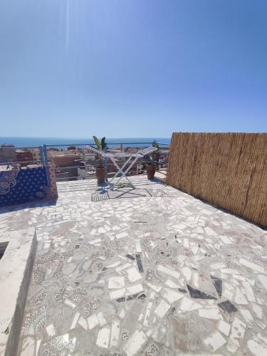 a tile roof with a view of the ocean at Blue Pearl Surf House Morocco in Oulad Akkou