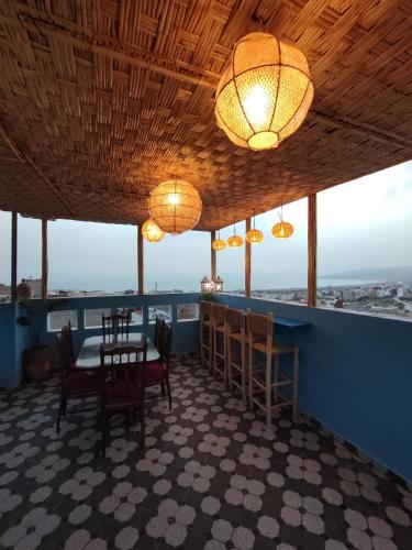 a dining room with a table and chairs and lights at Blue Pearl Surf House Morocco in Oulad Akkou