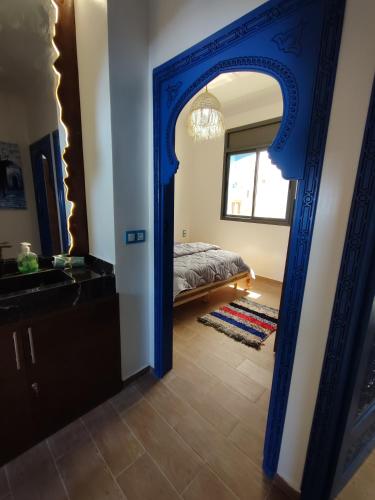 a bedroom with a bed and a blue mirror at Blue Pearl Surf House Morocco in Oulad Akkou