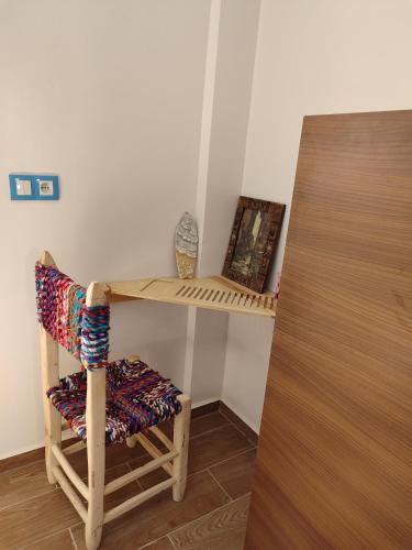 a chair sitting next to a table with a shelf at Blue Pearl Surf House Morocco in Oulad Akkou
