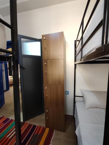 a dorm room with a bunk bed and a door at Blue Pearl Surf House Morocco in Oulad Akkou