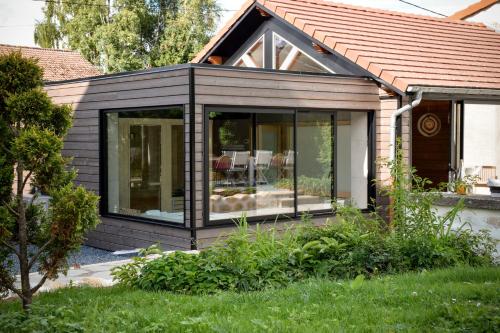 a black house with glass windows in a yard at Ciné Mirabelle 