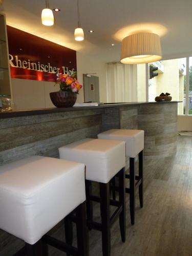 a bar with white stools in a restaurant at Hotel Rheinischer Hof Bad Soden in Bad Soden am Taunus
